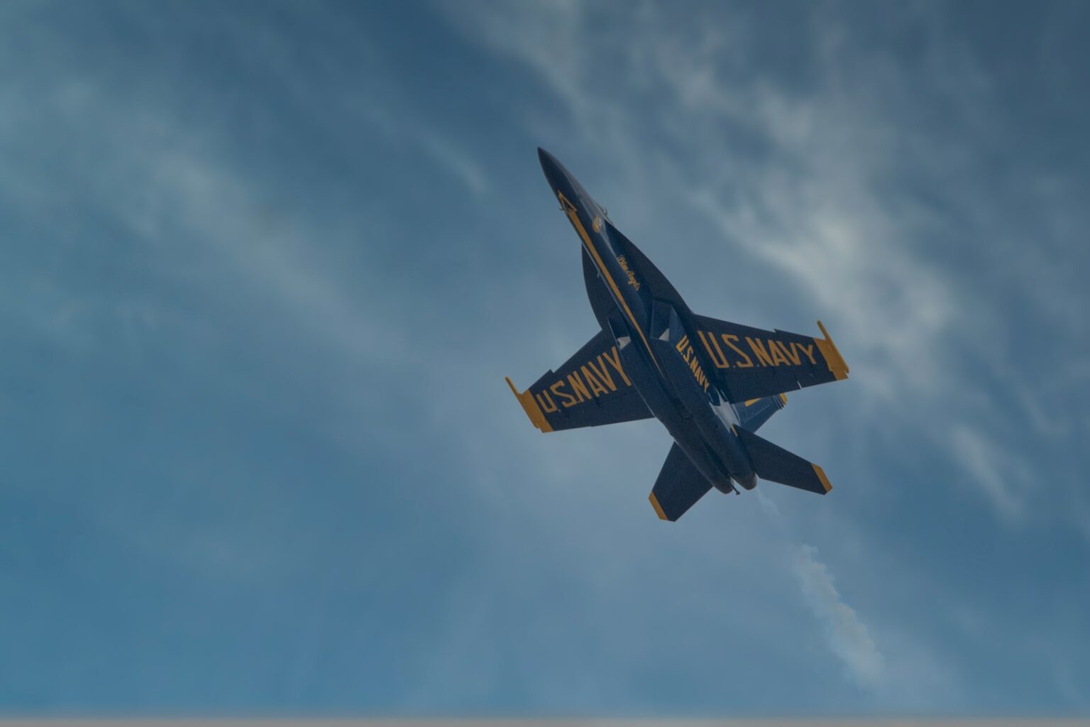 a blue and yellow plane flying in the sky